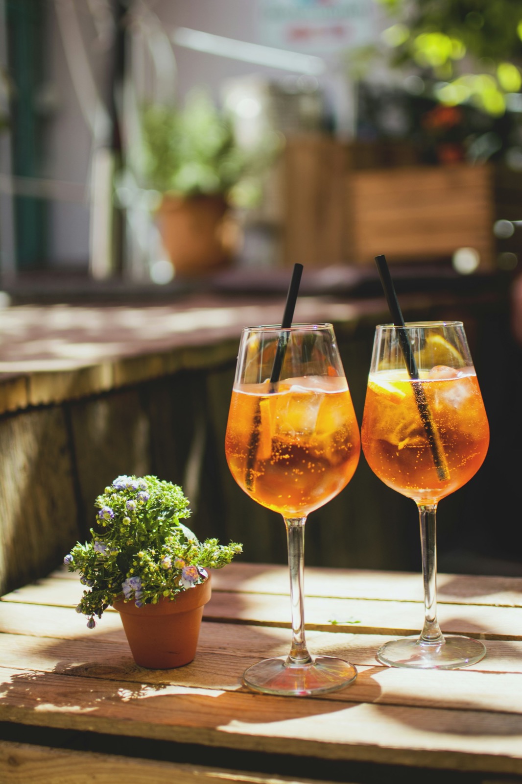 Two Aperol spritzes on a sunny patio table